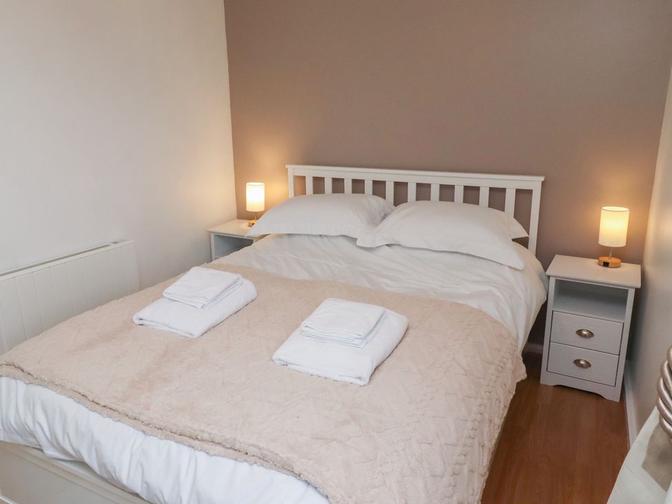 A bedroom with a bed and bedside table at Beadlin cottage Beadnell