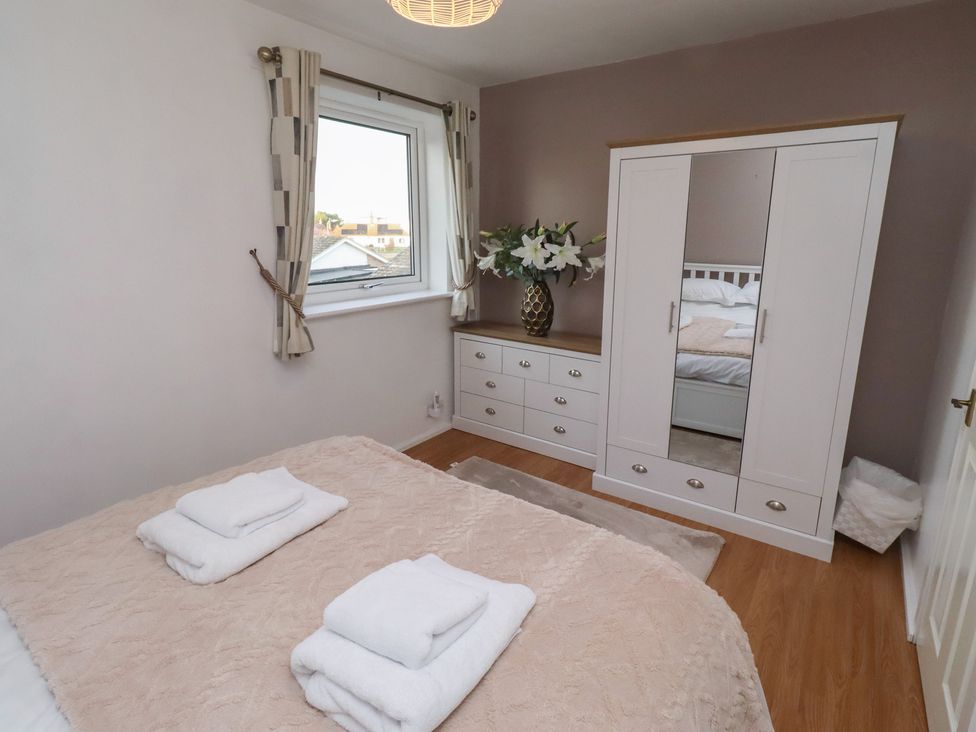 A bedroom with a bed and wardrobe at Beadlin cottage Beadnell