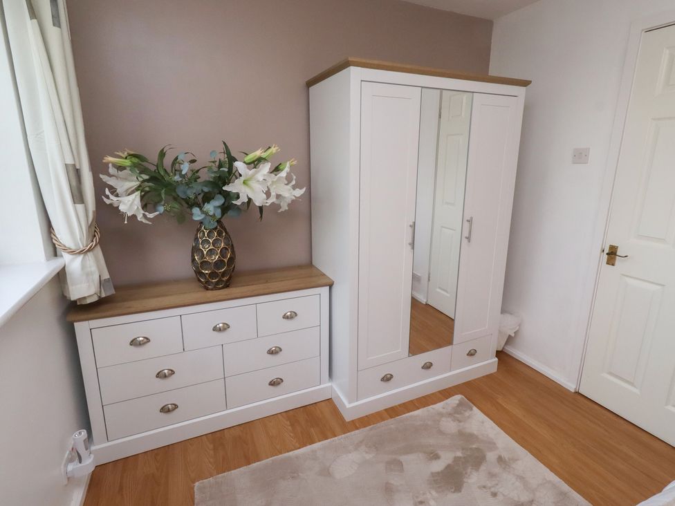 A bedroom with a chest of drawers and a wardrobe at Beadlin cottage Beadnell