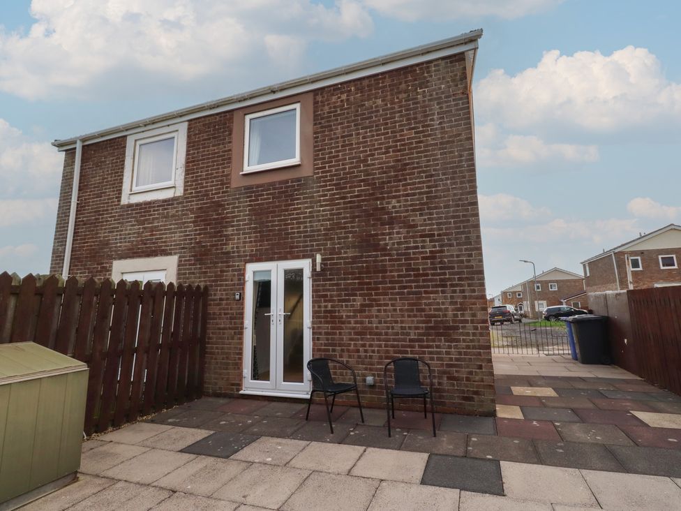 A house exterior with a patio and garden shed at Beadlin cottage Beadnell