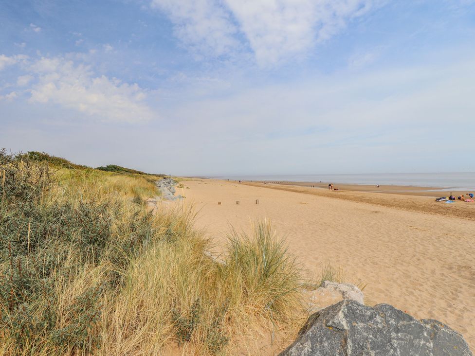 A beach with sand and grass at Atlas Moonstone in Ingoldmells
