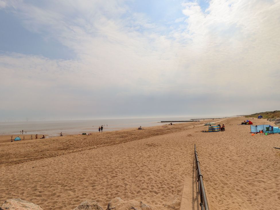 A beach with umbrellas and people at the shore