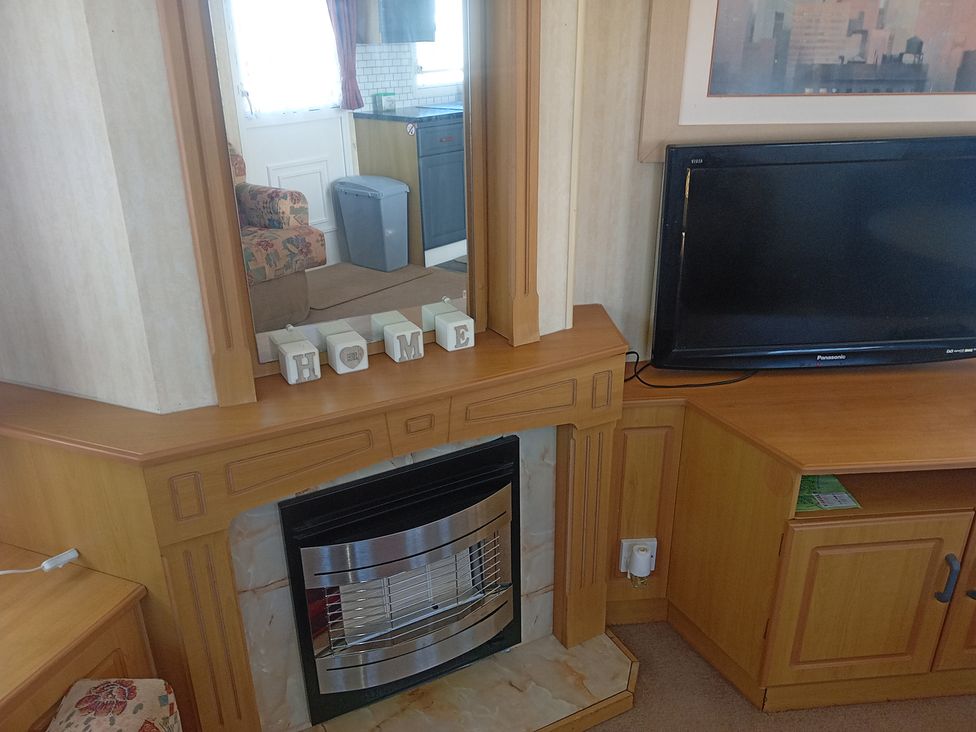 A living room with a fireplace and television at Atlas Moonstone in Ingoldmells