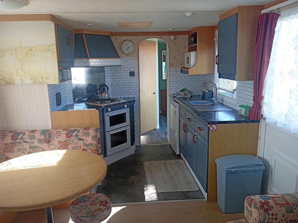 A kitchen with a table and chairs at Atlas Moonstone in Ingoldmells