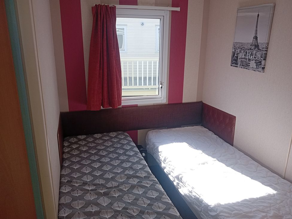 A bedroom with two beds and a window at Atlas Moonstone in Ingoldmells
