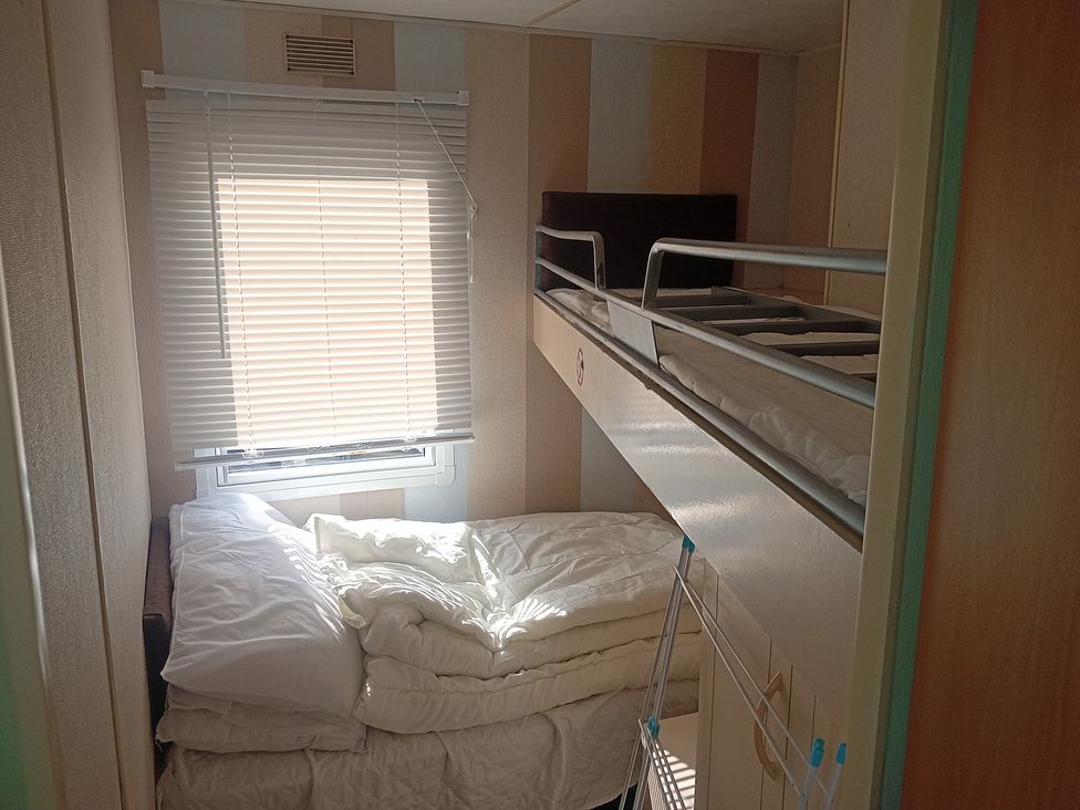A bedroom with a bunk bed and blankets at Atlas Moonstone in Ingoldmells