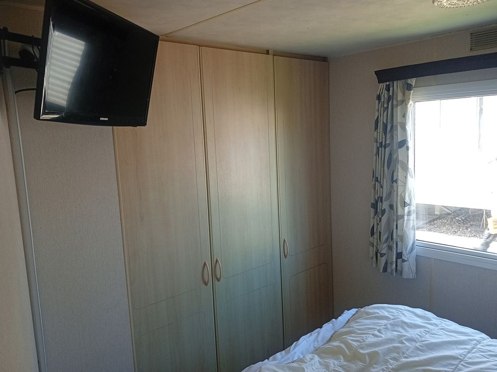 A bedroom with a wardrobe and television at Atlas Moonstone in Ingoldmells