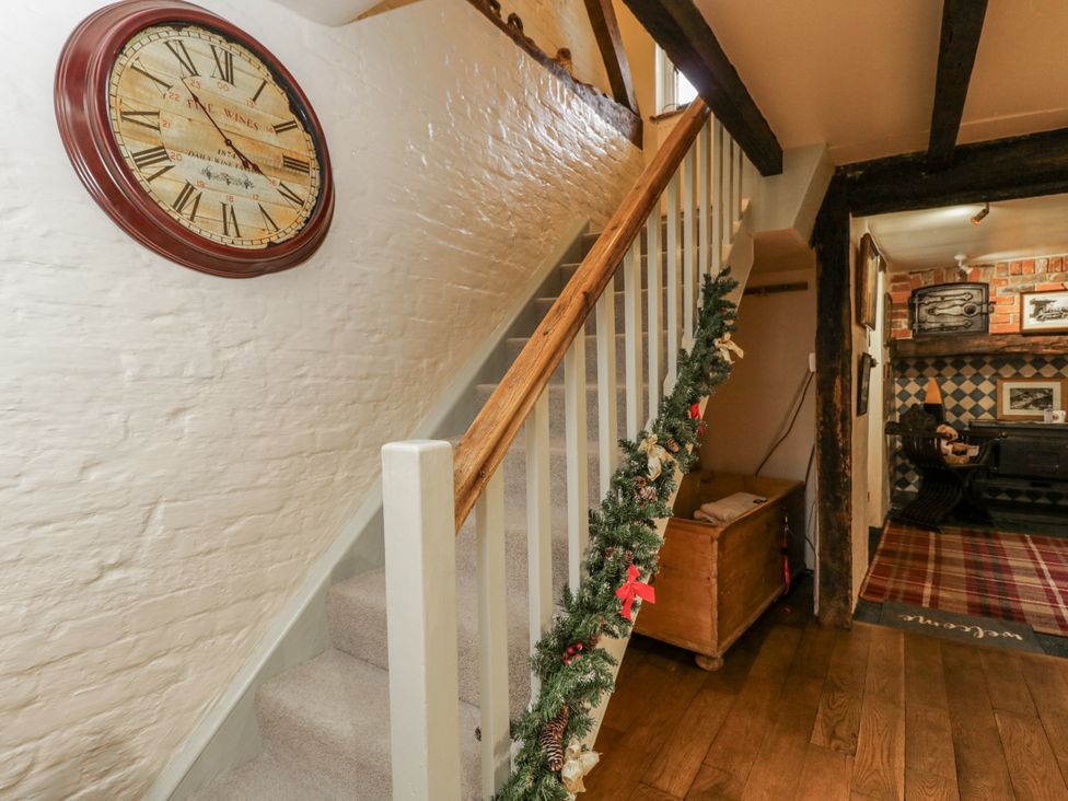 A staircase with a clock and garland in a hallway at 24 Eastcourt