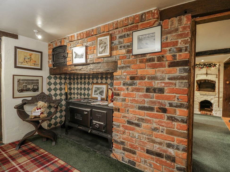 A snug with a stove, table, and pictures at 24 Eastcourt