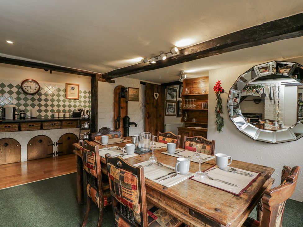 A dining room with a large table and kitchen elements at 24 Eastcourt