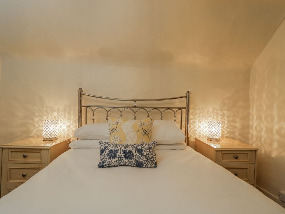 A bedroom with a bed and bedside tables at 24 Eastcourt