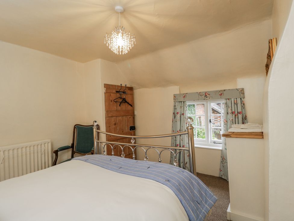 A bedroom with a bed, chair and window at 24 Eastcourt 