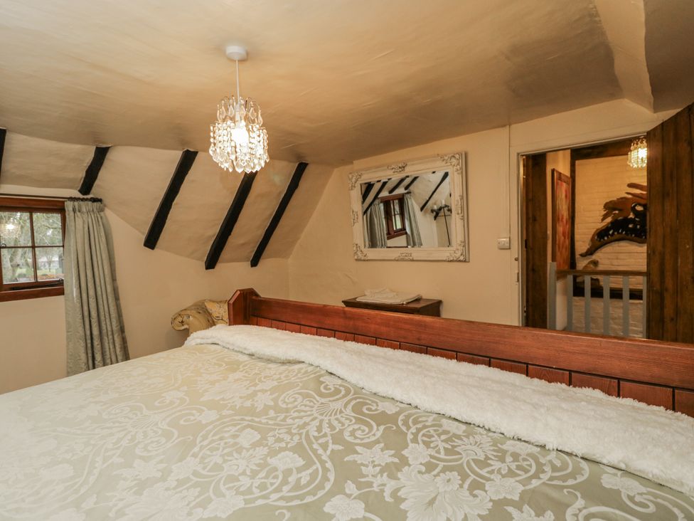 A bedroom with a bed and chandelier at 24 Eastcourt