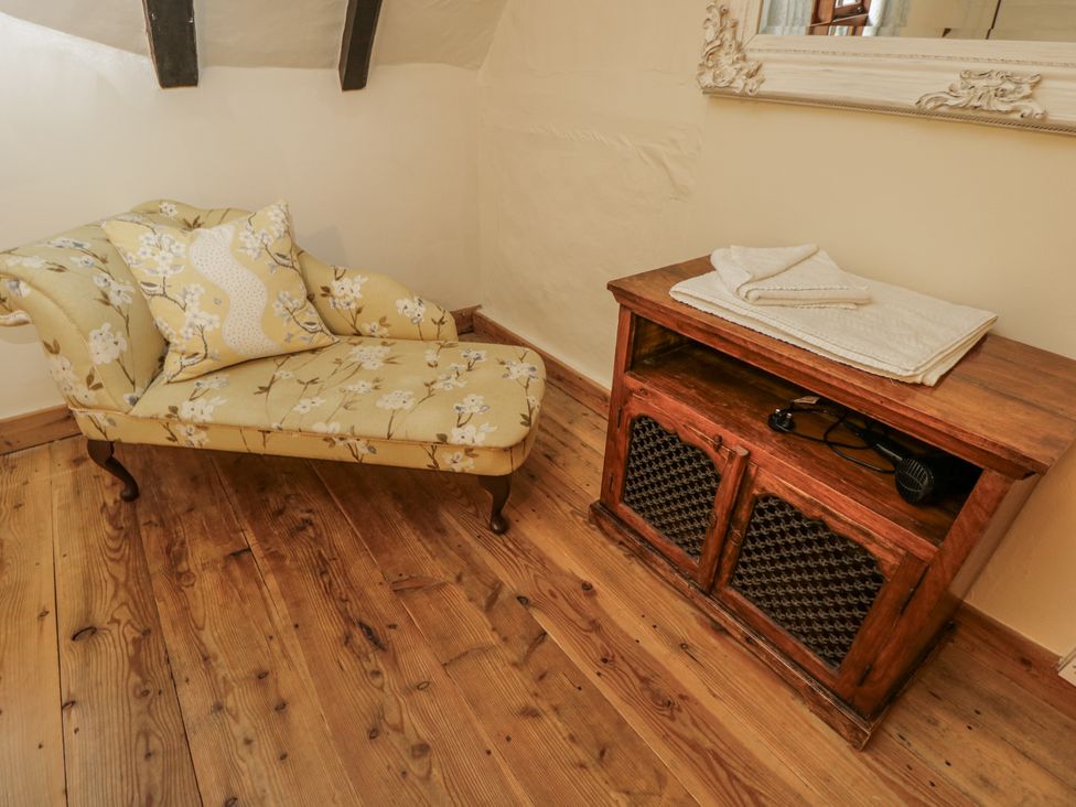 A snug with a chaise lounge and wooden table at 24 Eastcourt