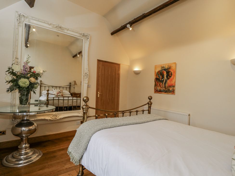 A bedroom with a bed and a large mirror at 24 Eastcourt