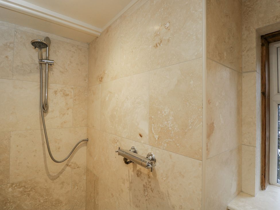 A shower area with tiles and a showerhead at 24 Eastcourt