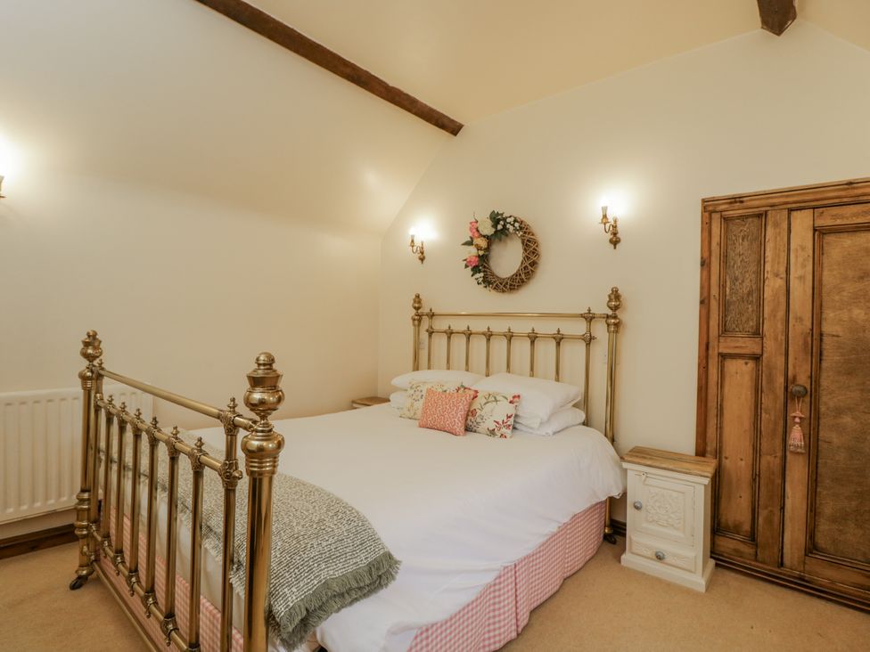 A bedroom with a bed and wooden wardrobe at 24 Eastcourt