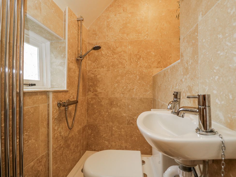 A bathroom with a shower, toilet, and sink at 24 Eastcourt