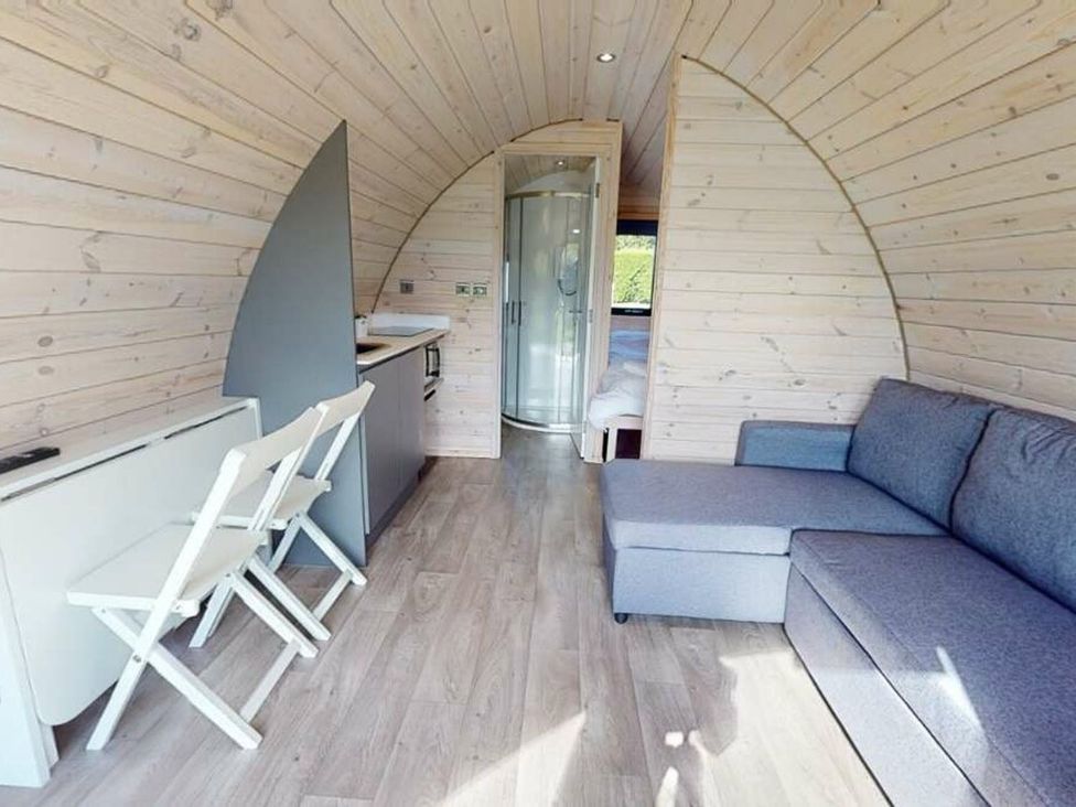 A pod interior with a sofa and kitchenette at Pod 1 (Pet Friendly) Carnforth