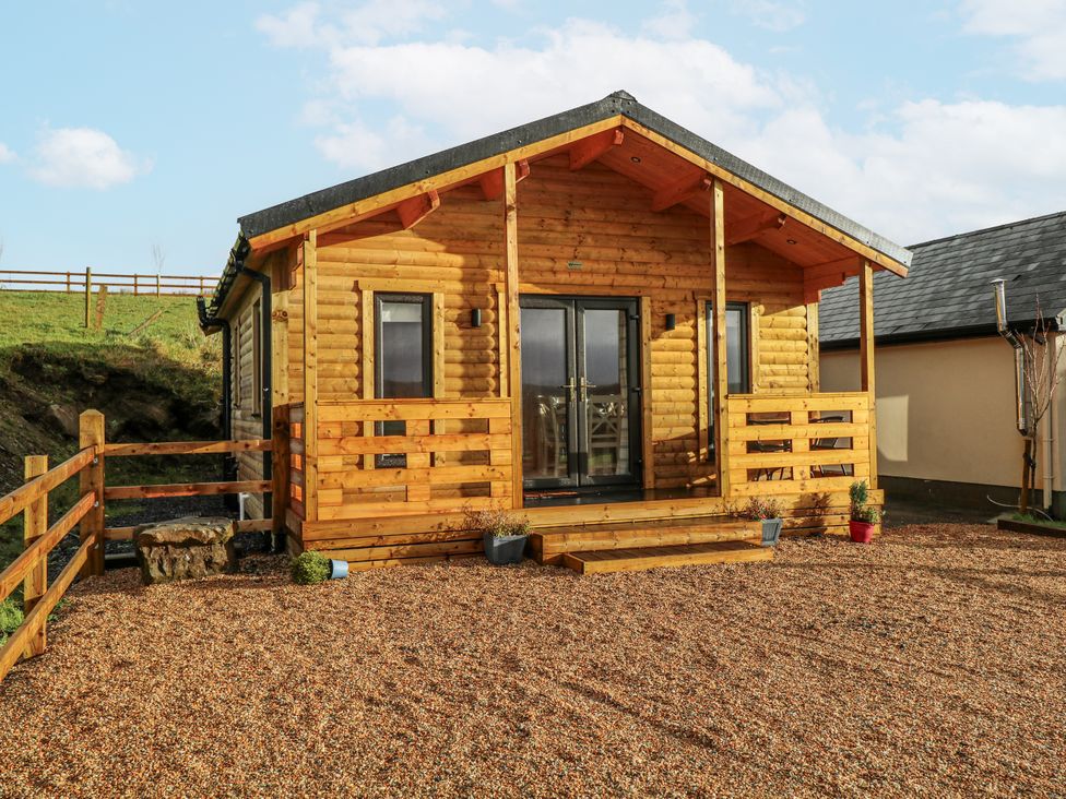 A log cabin with steps and gravel area at Glenview Log Cabin in Ballycastle