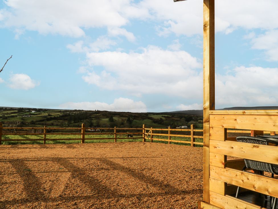 An outdoor space with a gravel area and a wooden fence at Glenview Log Cabin in Ballycastle