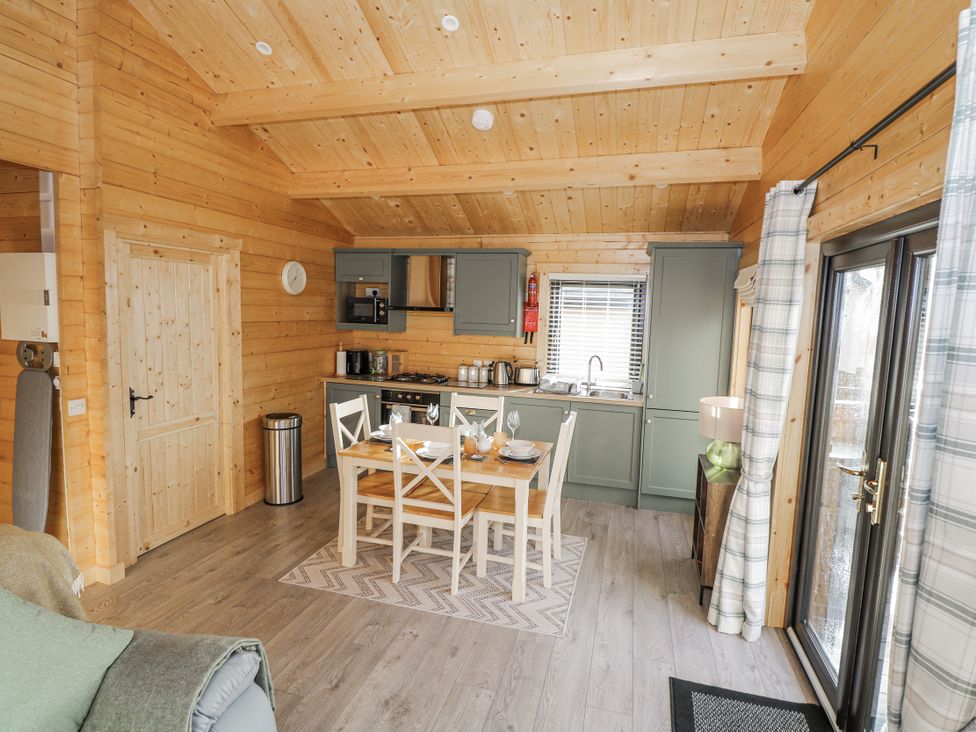 A kitchen with a table and chairs at Glenview Log Cabin in Ballycastle