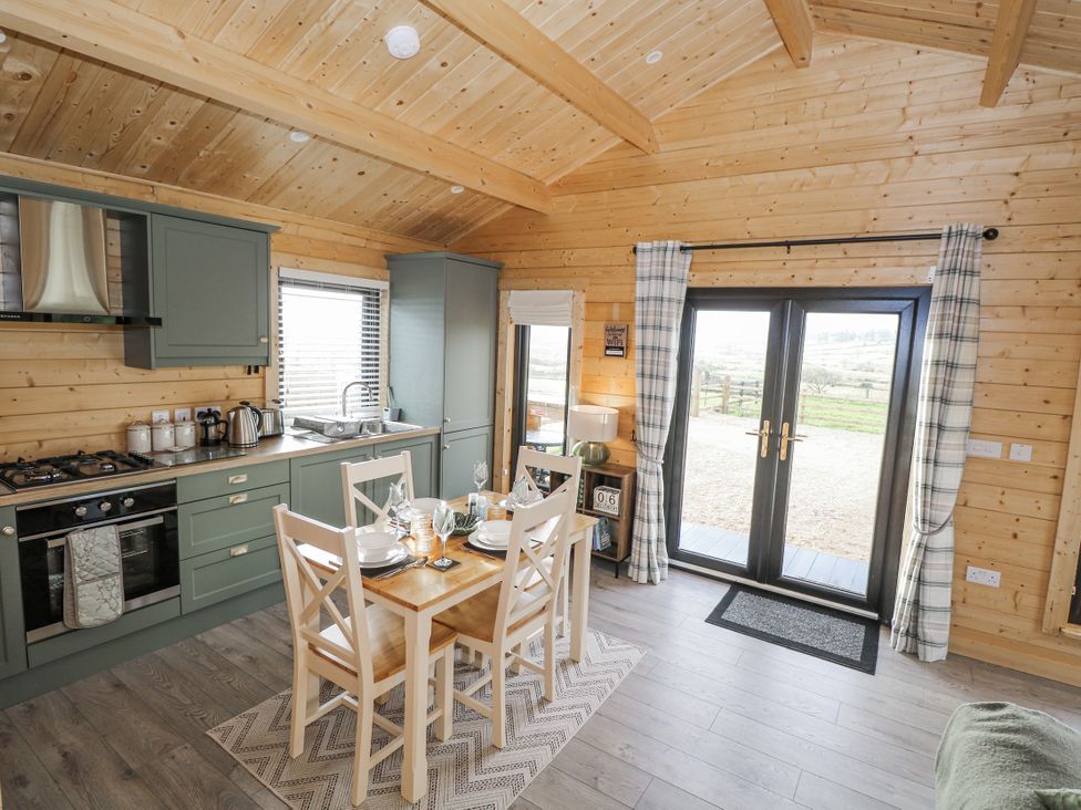 A kitchen with a dining table and four chairs at Glenview Log Cabin in Ballycastle