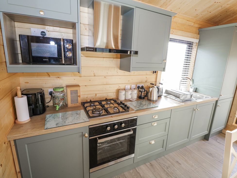 A kitchen with appliances and a sink at Glenview Log Cabin, Ballycastle