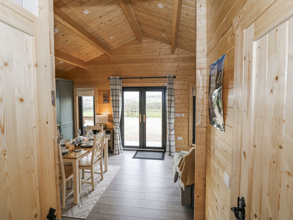 A living room with a dining table and chairs at Glenview Log Cabin in Ballycastle