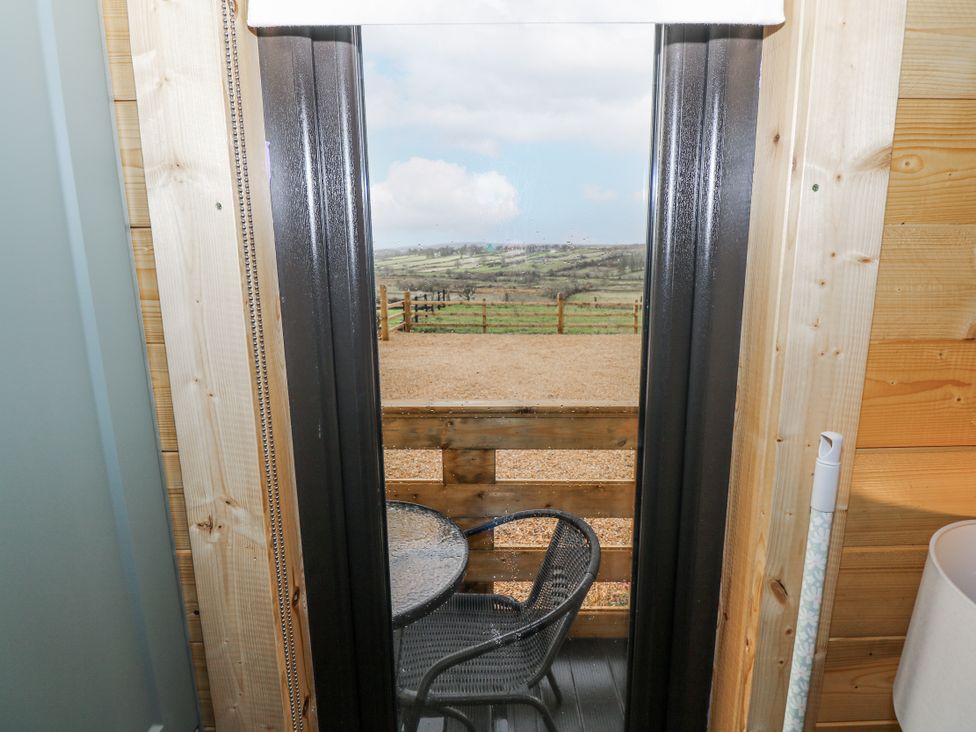 A view from a balcony with a table and chair at Glenview Log Cabin in Ballycastle
