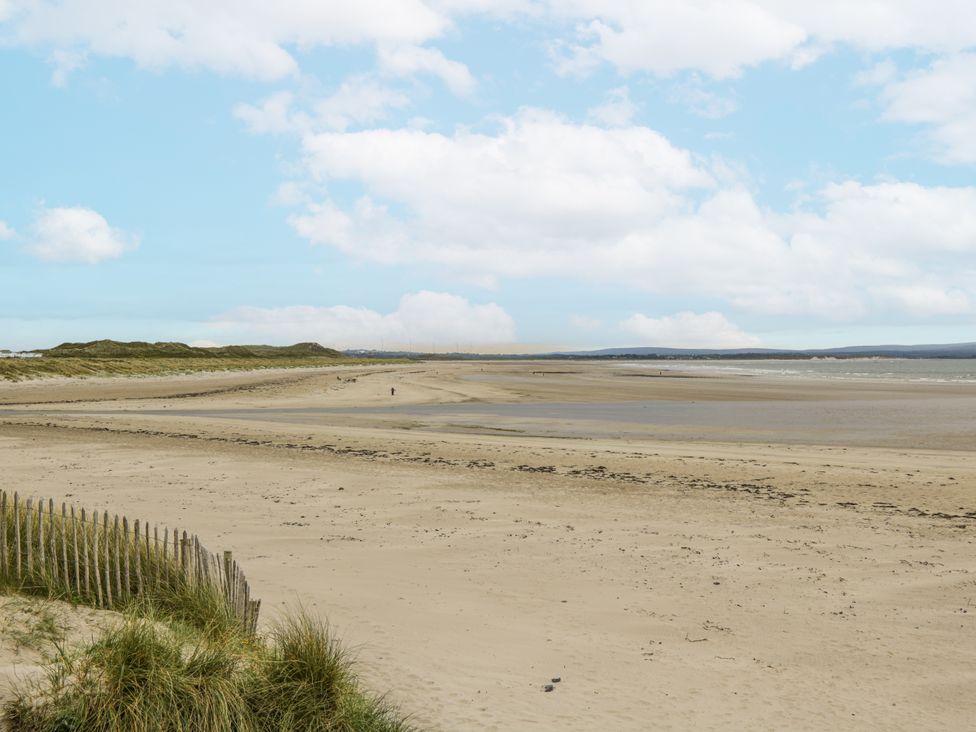 A beach with sand and dunes at Glenview Log Cabin in Ballycastle