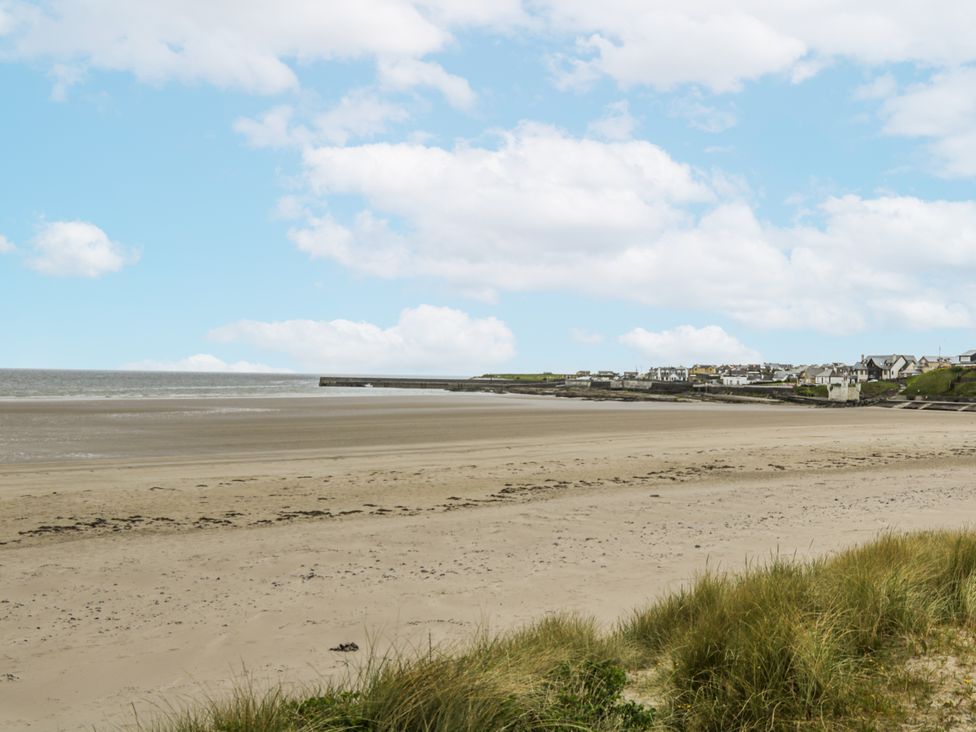 A beach with sand and a view of the sea at Glenview Log Cabin in Ballycastle