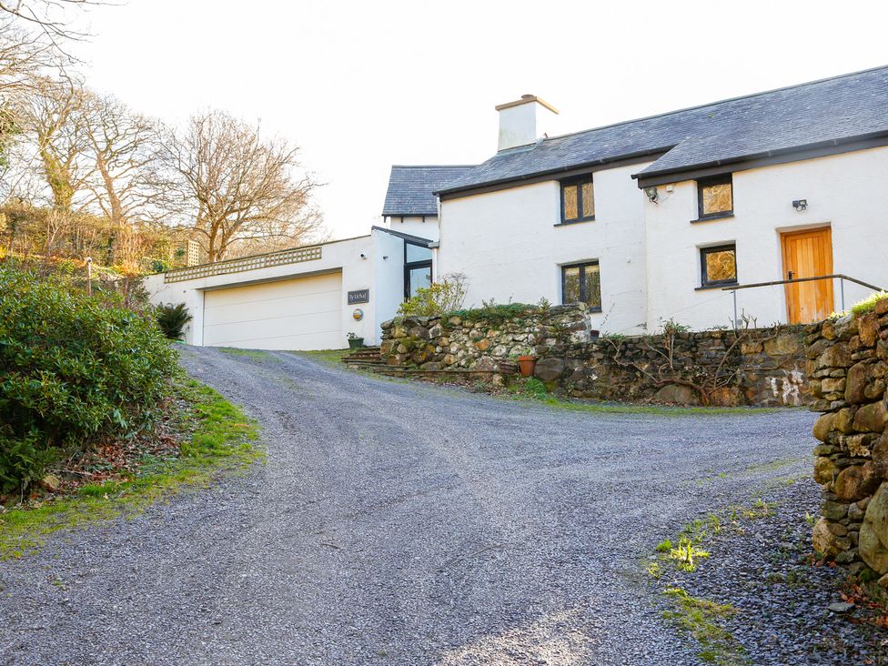 A house with a garage and a gravel driveway at Ty Uchaf in Colwyn Bay