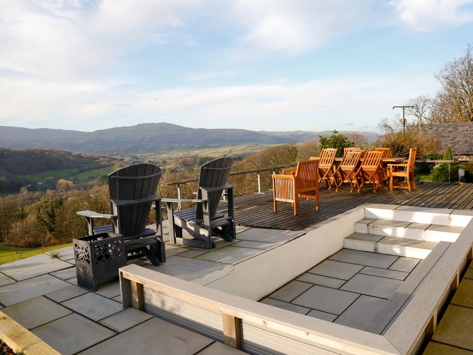 An outdoor area with chairs and a table overlooking a landscape at Ty Uchaf in Colwyn Bay