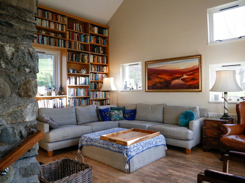 A living room with a sofa and bookshelf at Ty Uchaf in Colwyn Bay