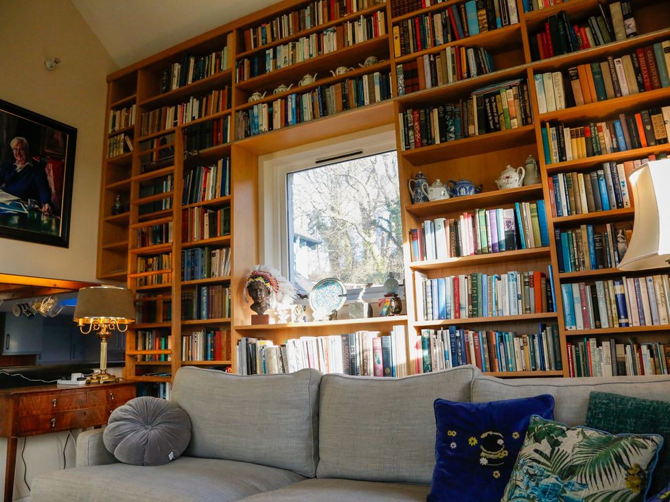 A living room with bookshelves and a lamp at Ty Uchaf in Colwyn Bay