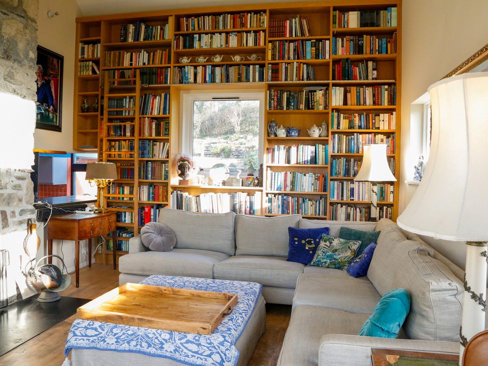 A living room with a bookshelf and sofa at Ty Uchaf in Colwyn Bay
