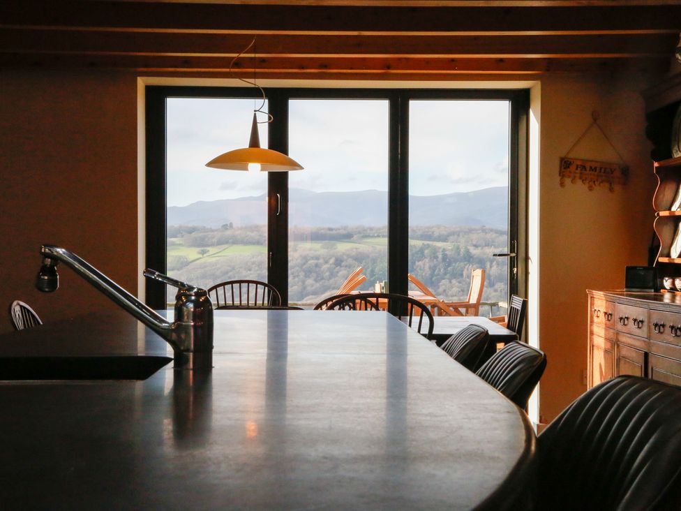 A kitchen with a dining table and large windows at Ty Uchaf in Colwyn Bay
