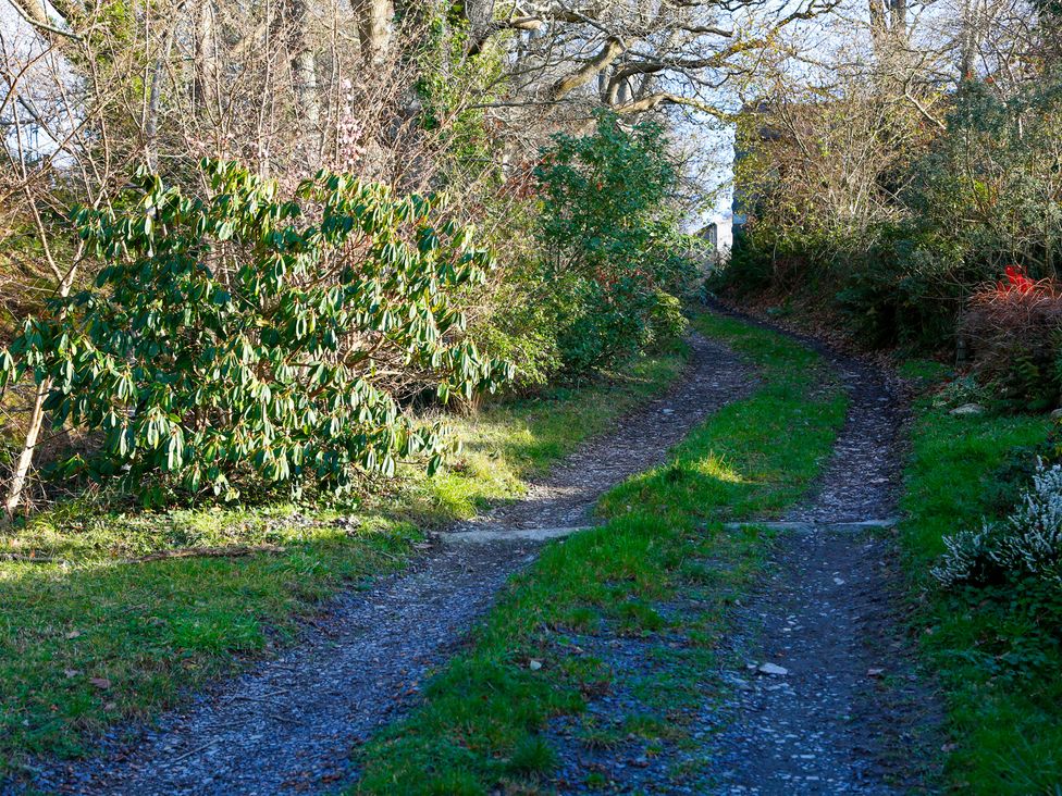 A gravel path surrounded by bushes and trees at Ty Uchaf in Colwyn Bay