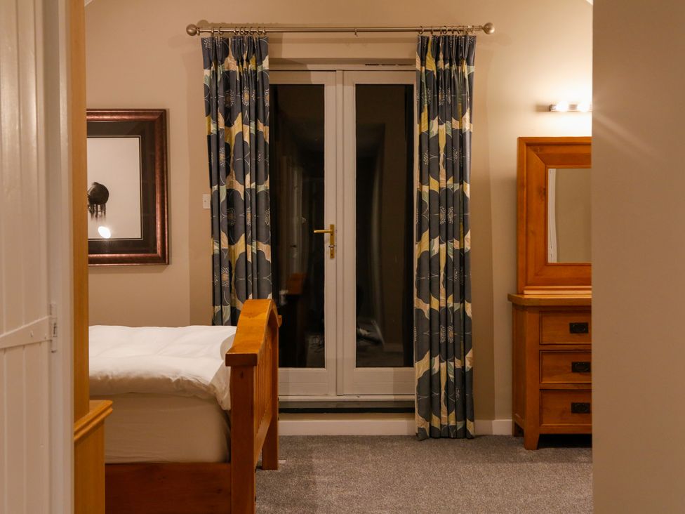 A bedroom with a bed and dresser at Ty Uchaf in Eglwysbach