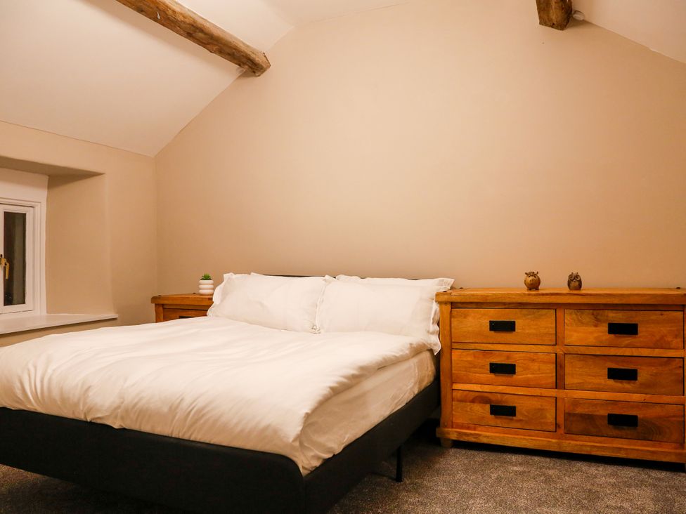 A bedroom with a bed and dresser at Ty Uchaf in Eglwysbach