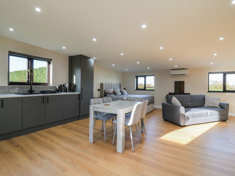 A living room with kitchen and seating area at Aloe Lodge in Diss