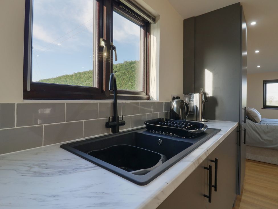 A kitchen with a sink and kettle at Aloe Lodge in Diss