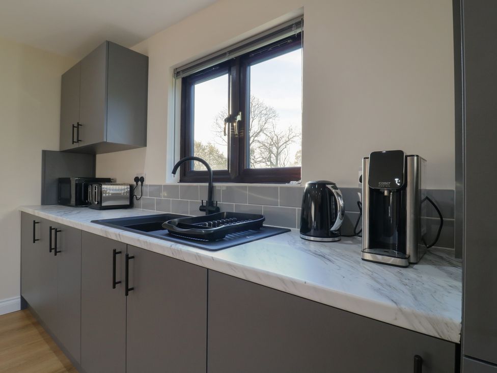 A kitchen with a sink and appliances at Aloe Lodge in Diss