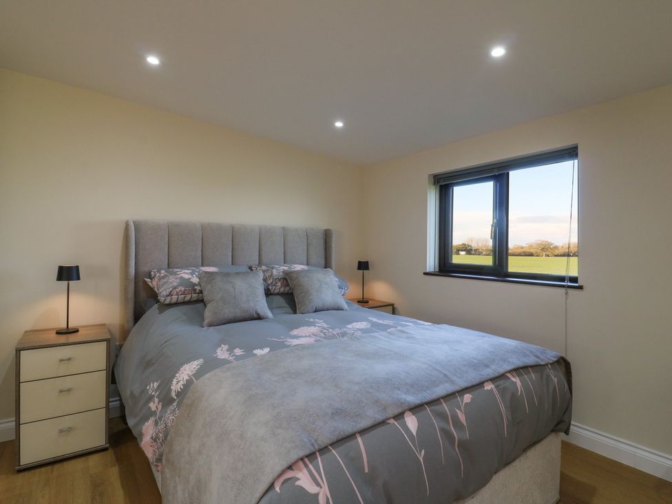 A bedroom with a bed and bedside lamps at Aloe Lodge in Diss