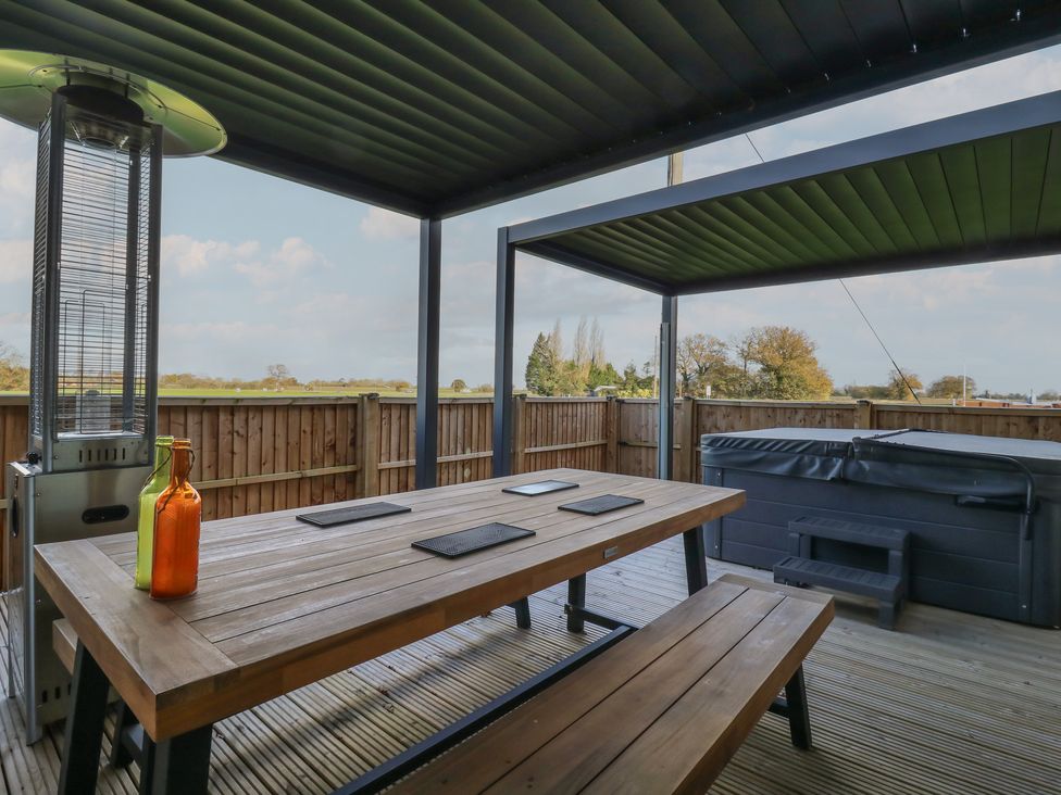An outdoor dining area with a table and chairs at Aloe Lodge in Diss