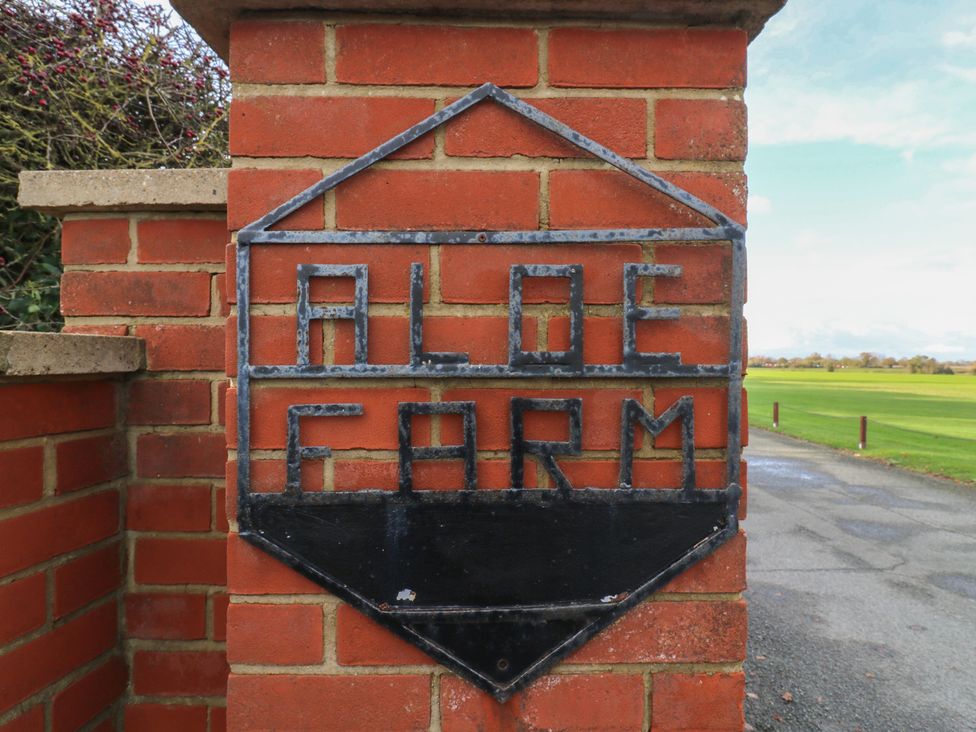 A sign reading Aloe Farm on a brick wall at Aloe Lodge in Diss