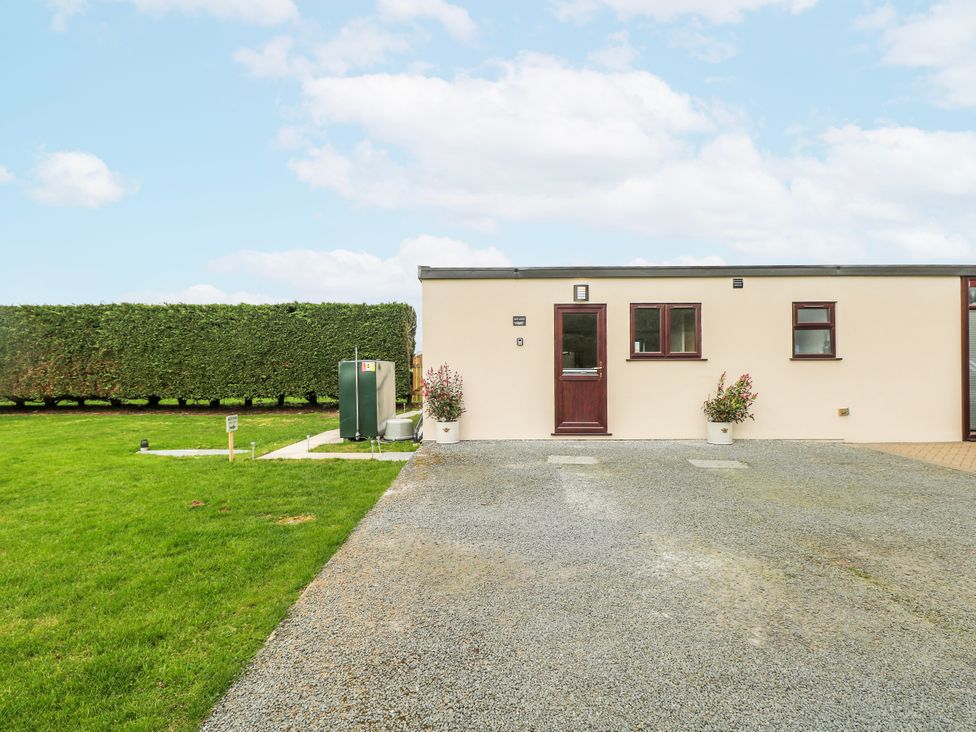 An exterior view of a lodge with a door and windows at Aloe Lodge in Banham