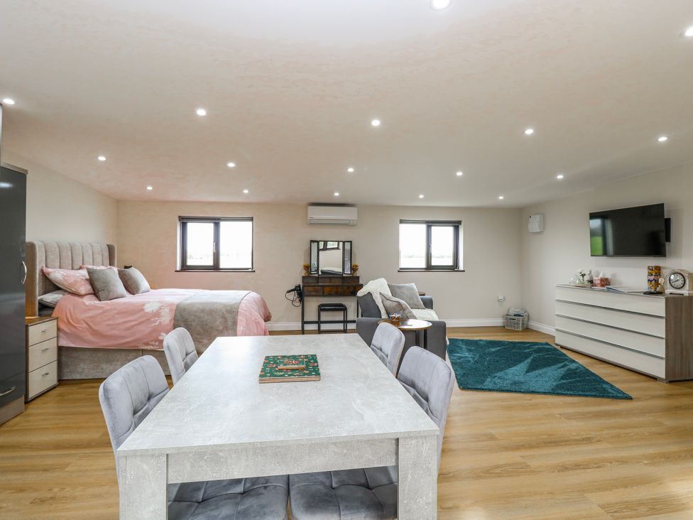 A studio with a bed and dining table at Aloe Lodge in Banham