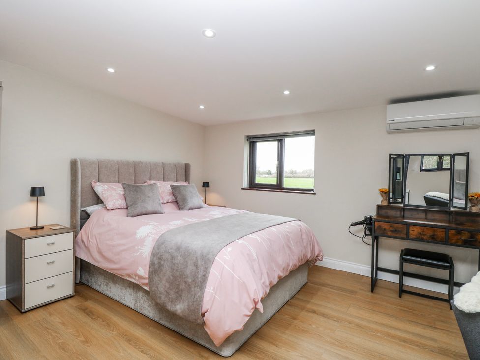 A bedroom with a bed and dressing table at Aloe Lodge Banham